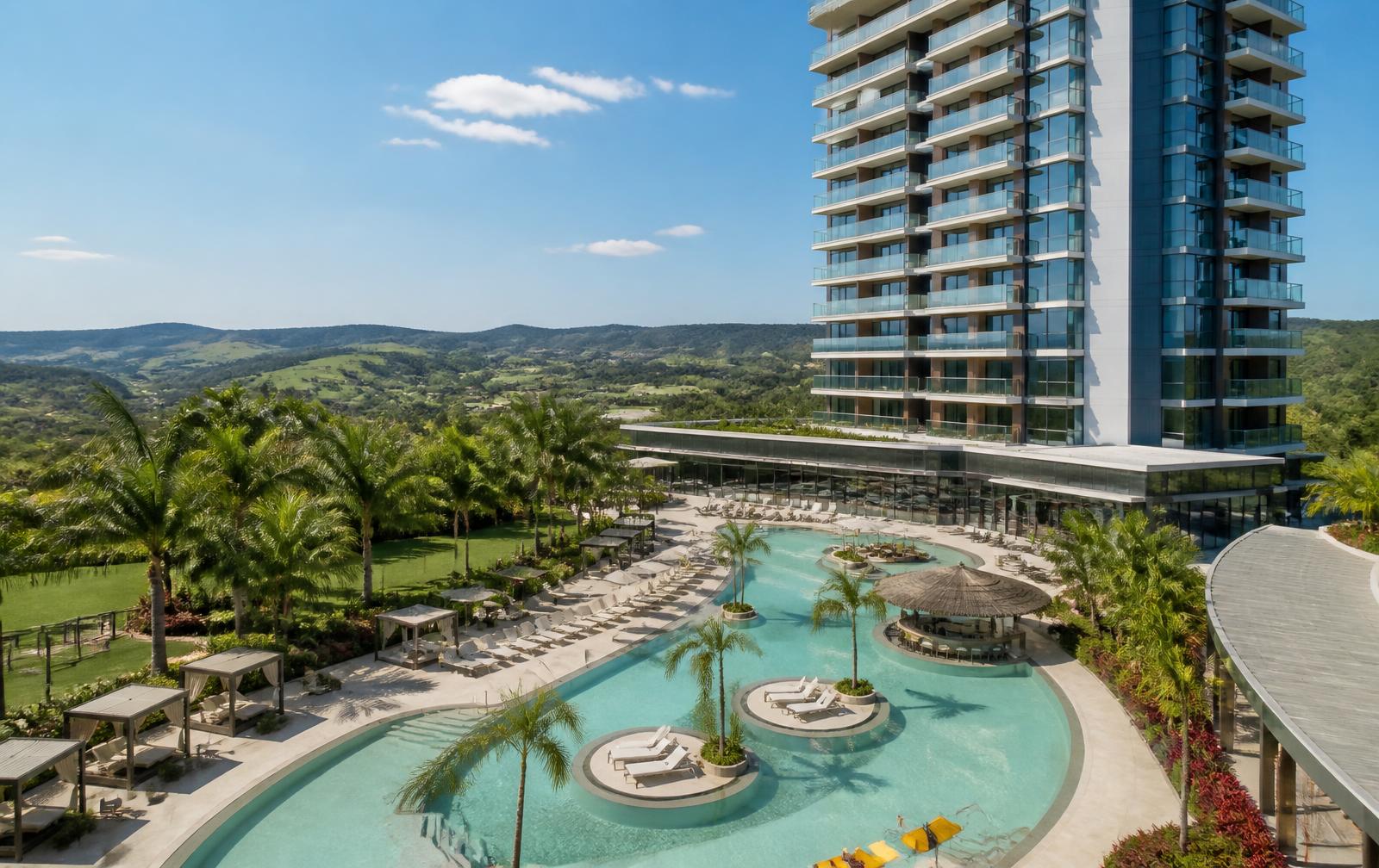 Torre moderna do Wyndham Olímpia Royal Hotels com piscinas em primeiro plano
